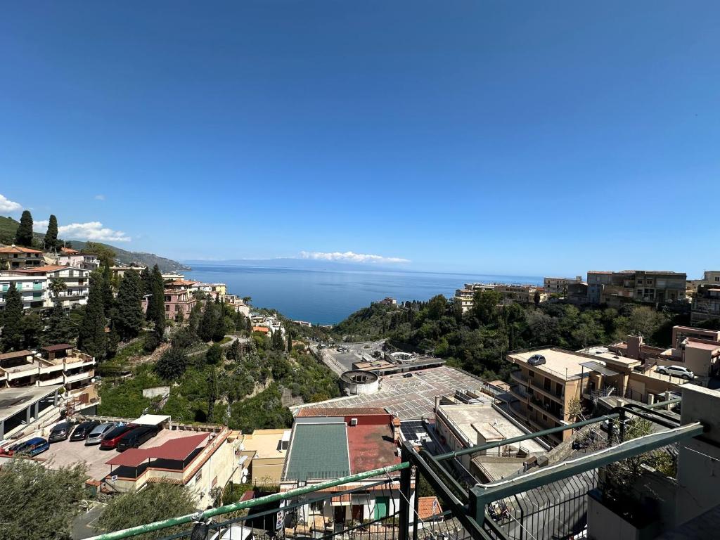a view of a city with the ocean in the background at Taormina Sky View in Taormina