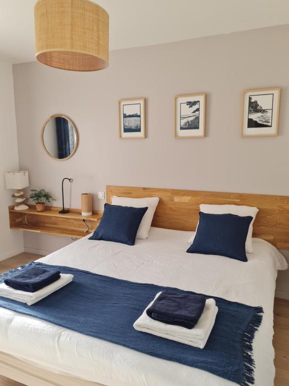 a bedroom with a bed with blue towels on it at Escale à Kergrenn in Fouesnant