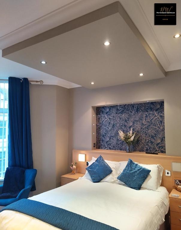 a bedroom with a large bed and a blue chair at The Norwood Hotel in Blackpool