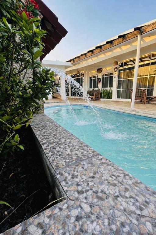 a swimming pool with a fountain in front of a building at Baru chachalacas in Chachalacas