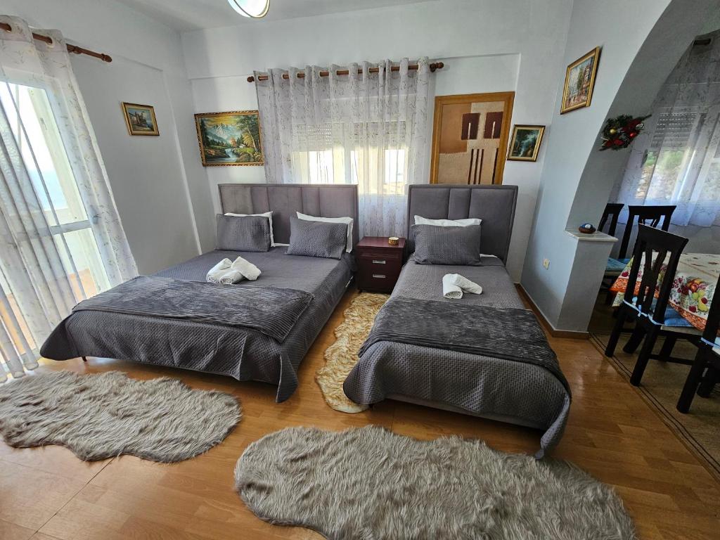 two beds in a room with rugs at Petrit apartament in Qeparo
