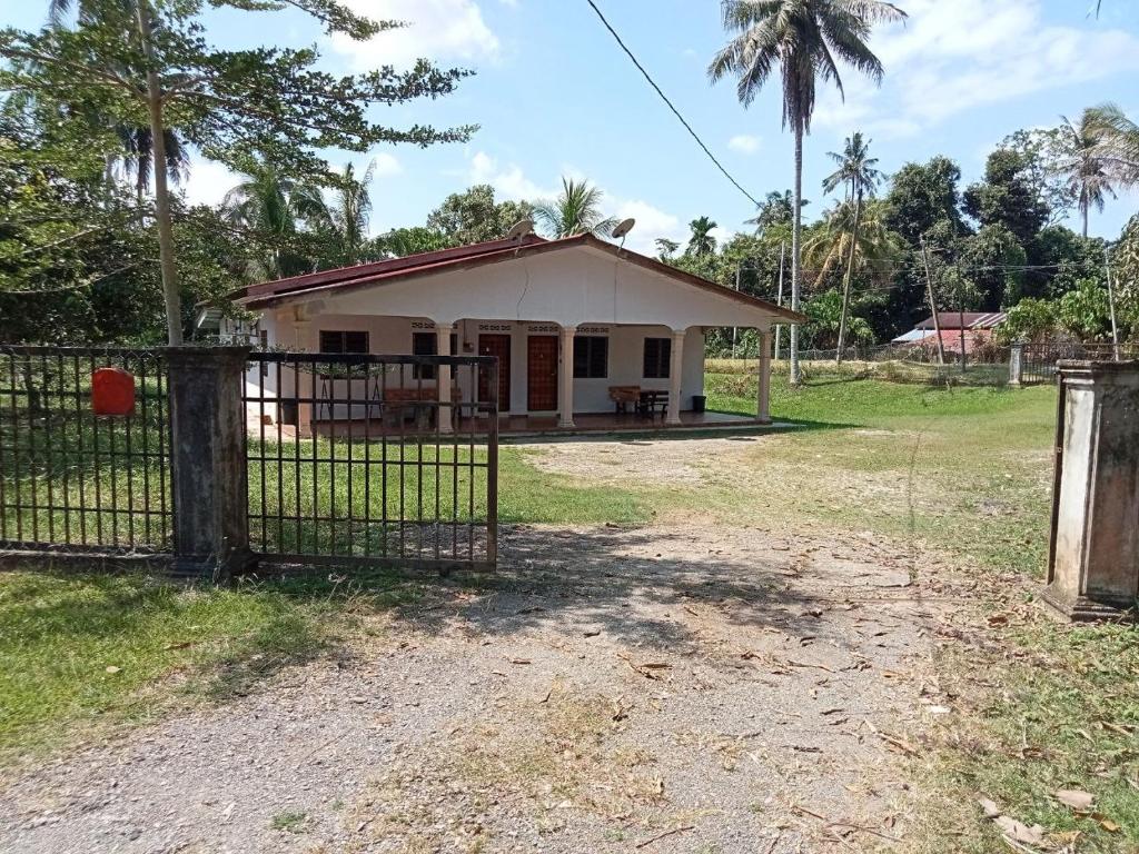 a small house with a gate in front of it at Hanny Cozy Homestay in Kuala Lipis