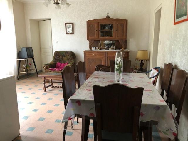 a dining room with a table and chairs and a room at le logis des Chabannes in Saint-Angel