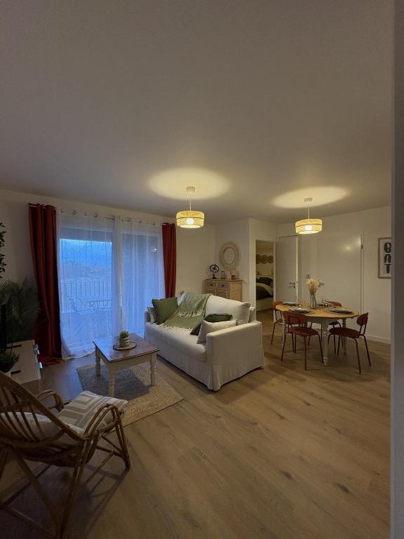 a living room with a white couch and a table at Ecrin de nacre Appartement de Standing in Courseulles-sur-Mer