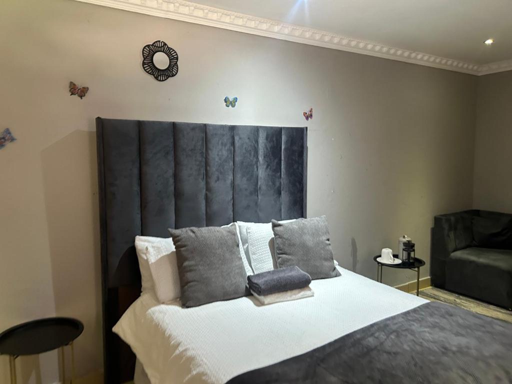 a bedroom with a large bed with a black headboard at Homely Palace in Midrand