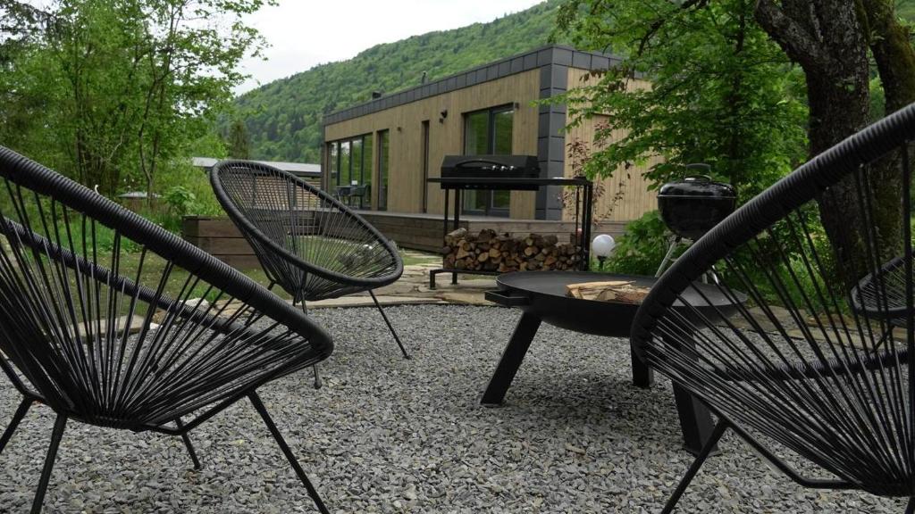 two black chairs and a grill in a backyard at Paporoti House in Korostov
