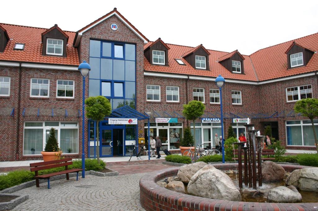 a building with a fountain in the middle of a street at Sporthotel Middelpunkt in Aurich