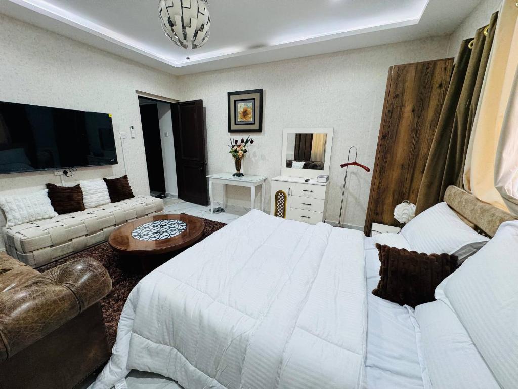 a living room with a white bed and a couch at Velmora Cozy 2BR Apartment 20 in Abu Dhabi