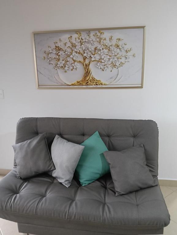 une photo d'un arbre au-dessus d'un canapé avec des coussins dans l'établissement Hospedaje samfer, à Envigado