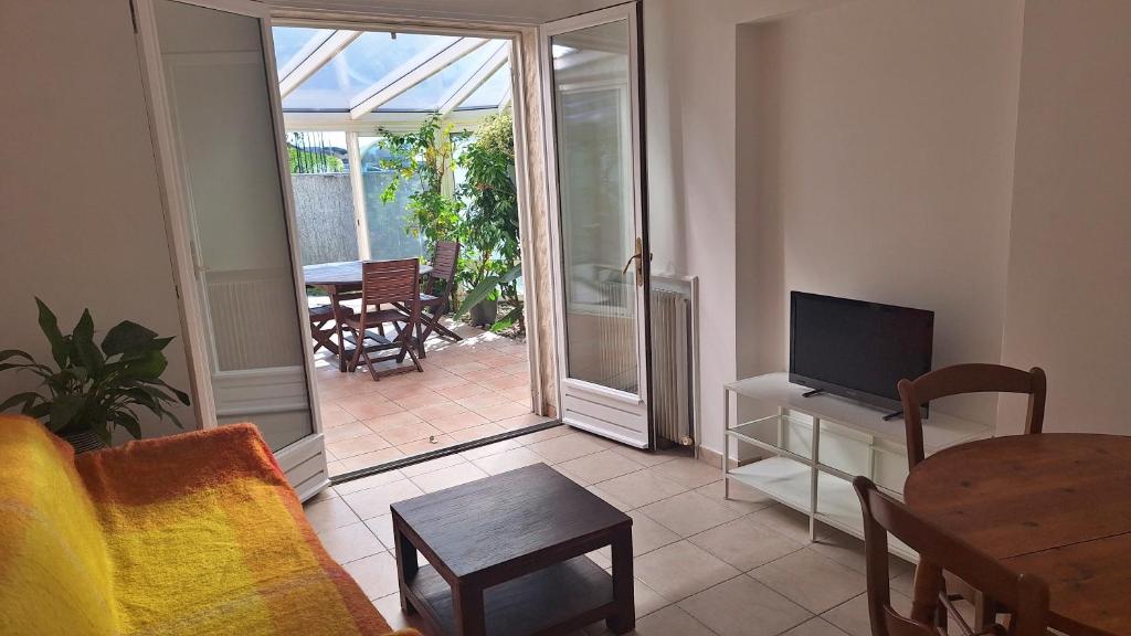 a living room with a couch and a television and a table at Gite d'Ossau in Lescar