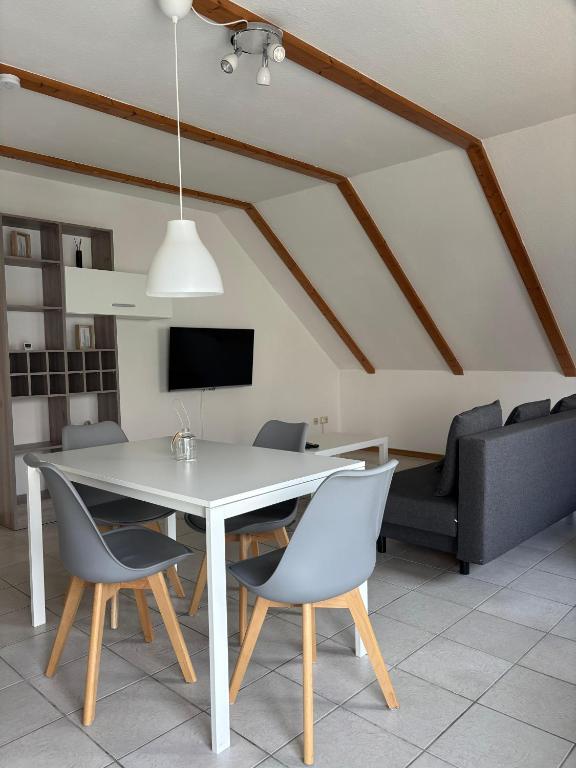 a dining room with a white table and chairs at FEWO Eggenstein beim KIT in Eggenstein-Leopoldshafen