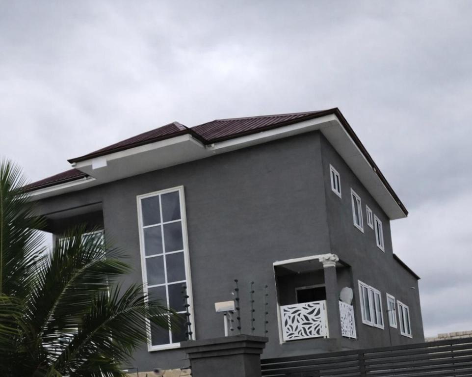a gray house with a door and a window at J-Ver Haven in Kasoa