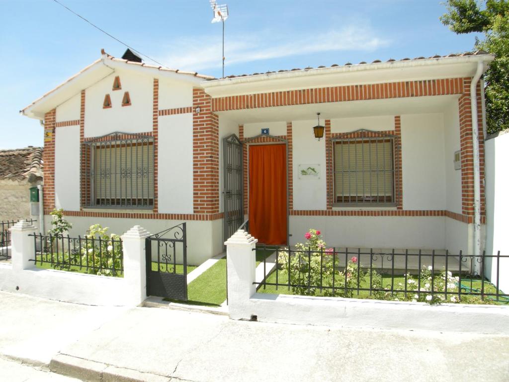 a house with a gate and a red door at Casa rural El Laurel in Chañe