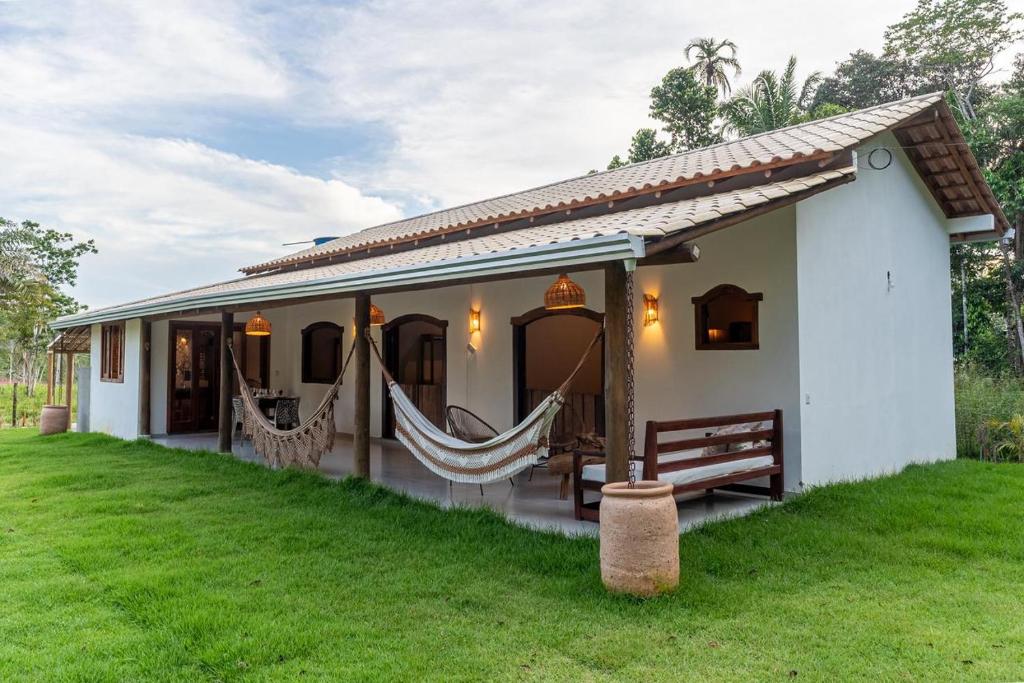 a small house with hammocks in the yard at Casa Xibas e Loft Trancoso in Trancoso