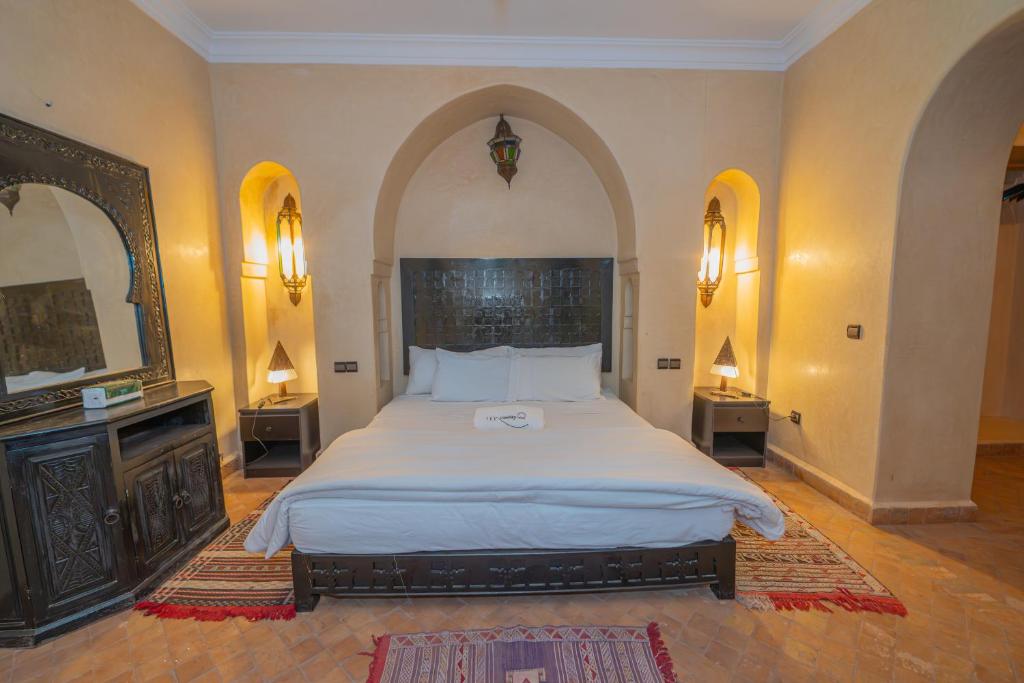 a bedroom with a large bed and two mirrors at Mumtaz Dar in Marrakesh