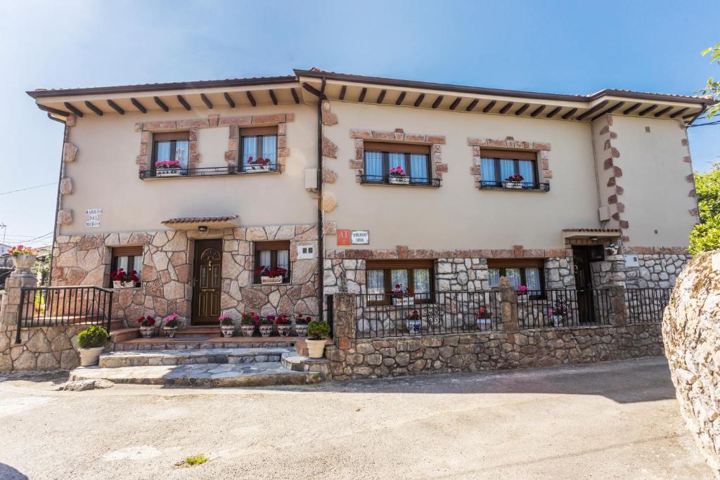 a large stone house with windows and a fence at Apartamentos Carolina in Celorio