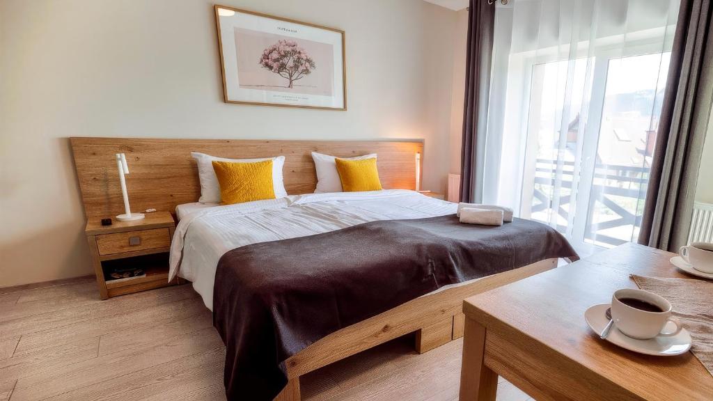 a bedroom with a large bed with yellow pillows at Rezydencja Pod Ochorowiczówką B&B in Wisła