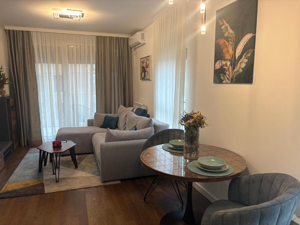 a living room with a couch and a table at Azure Living Apartman in Kragujevac