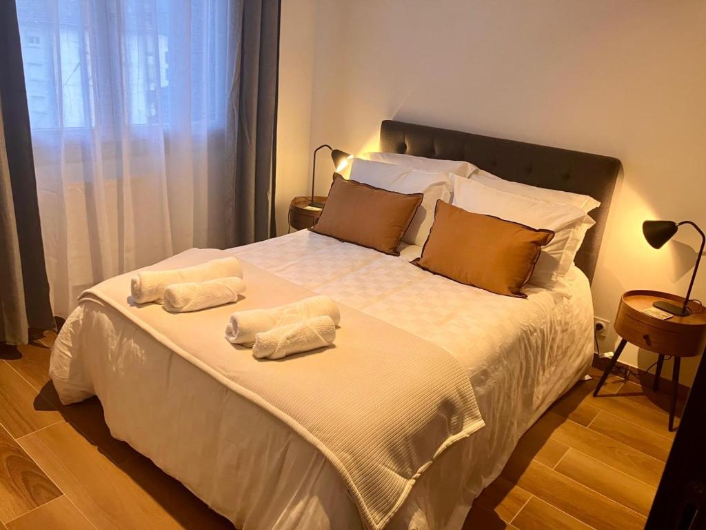 a bedroom with a large white bed with towels on it at Calm & Cozy Apartment with Parking in Sallanches in Sallanches