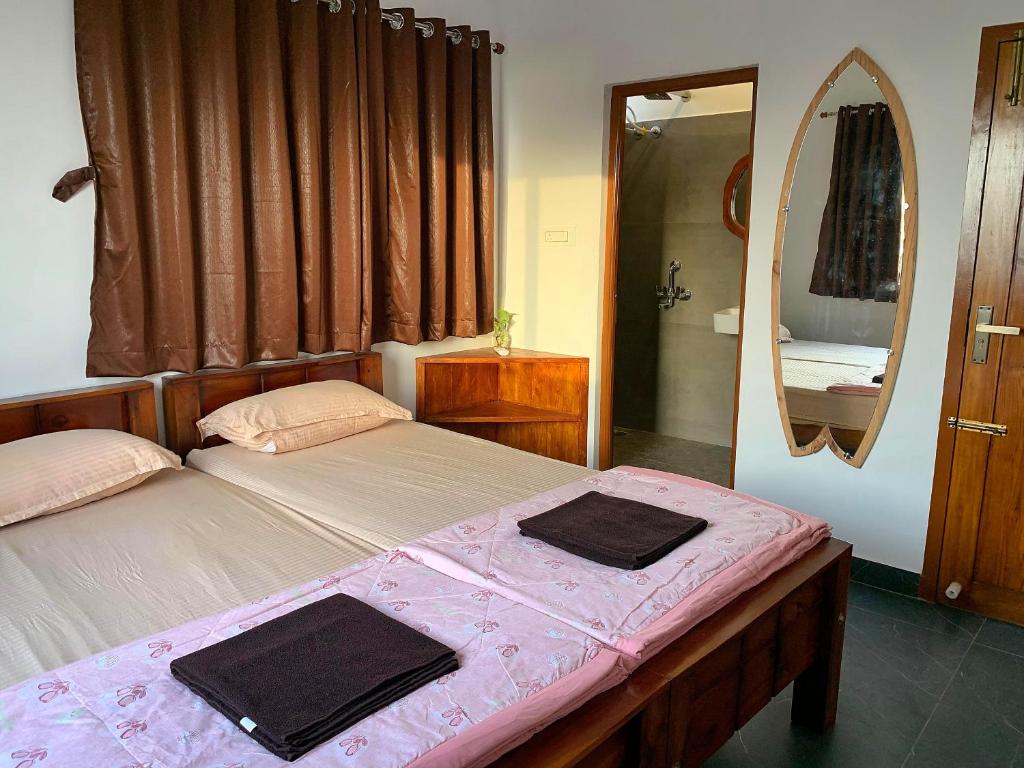 a bedroom with two beds and a mirror at Murthy Surf School in Covelong
