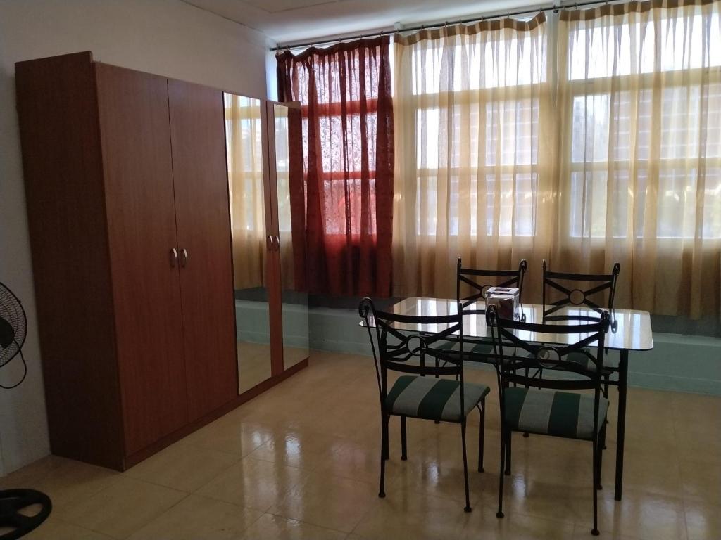 a dining room with a table and chairs and windows at Cádiz bahía in Cádiz