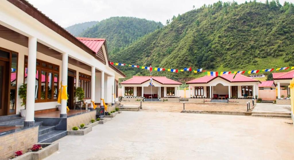 a group of buildings with a mountain in the background at Rivero Resort in Dirang Dzong