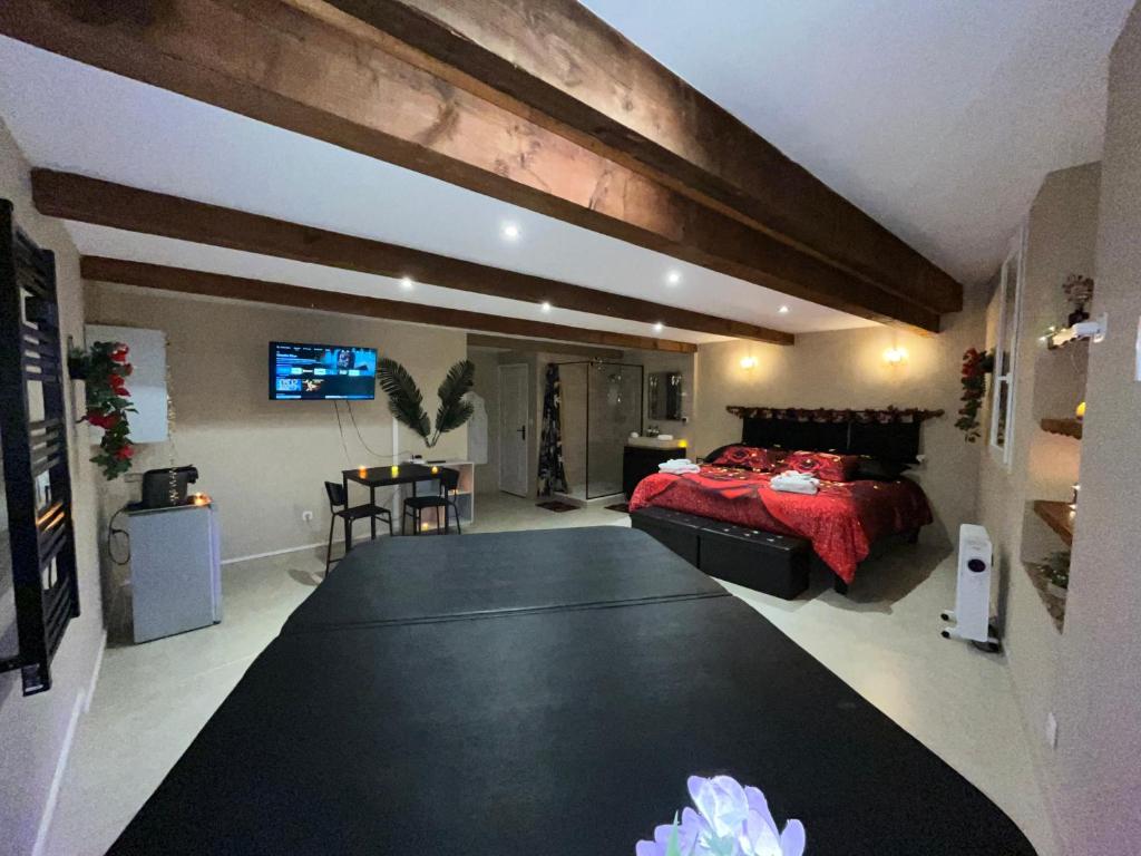 a bedroom with a bed and a table in a room at Le Cocon SPA Évasion Privée - jacuzzi - in Lunel