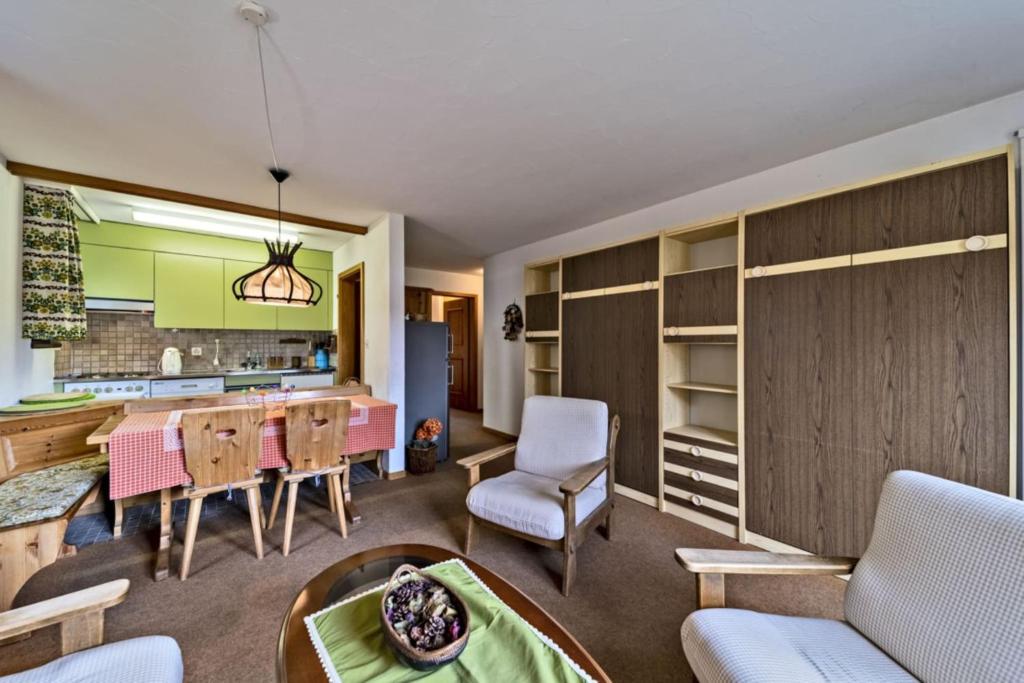 a kitchen and living room with a table and chairs at Chesa Chamuotsch - Celerina in Celerina