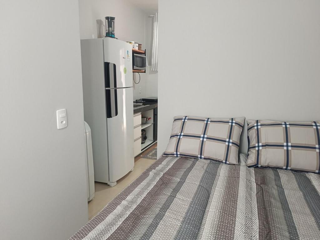 a bedroom with two beds and a refrigerator at Loft mobiliado in Joinville