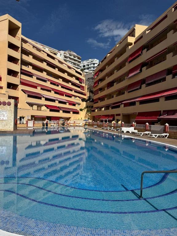 a large swimming pool in front of some buildings at Casa de Rufio With Pool Tenerife in Puerto de Santiago