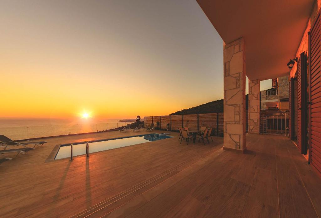 a view of the sunset from the deck of a house at Orient Villas Deluxe in Volimes