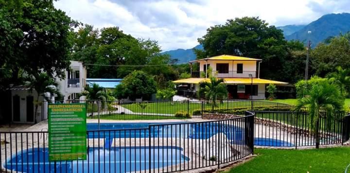 a fence in front of a house with a pool at Llano grande rivera in Rivera