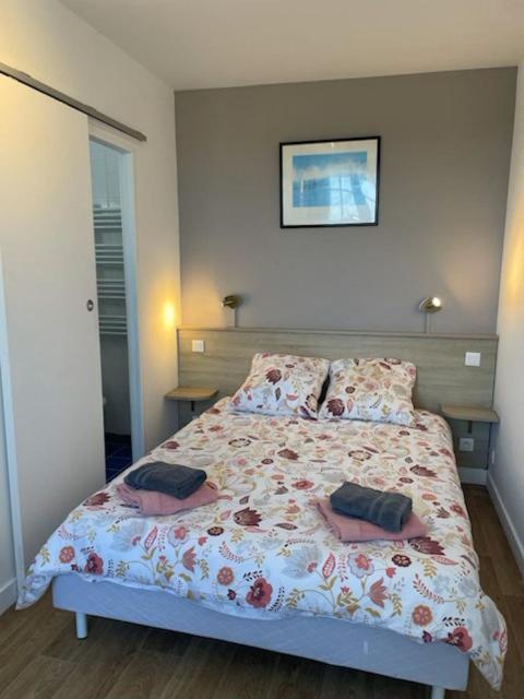 a bedroom with a bed with two pillows on it at Le OUESSANTIN in Lampaul