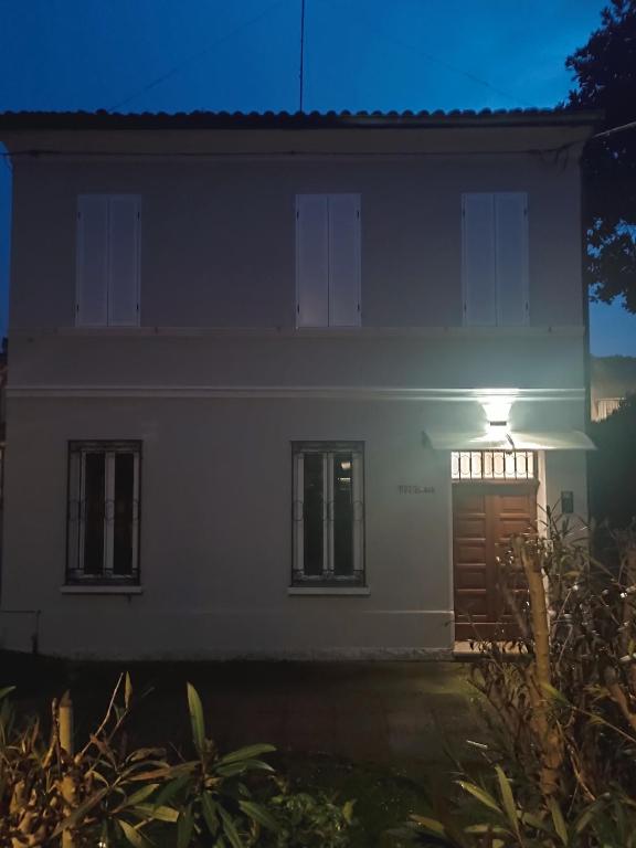 a white house at night with a light on the door at MTB b&b in Alfonsine