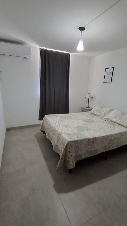 a white bedroom with a bed and a window at SLC San Martín 4 in San Luis