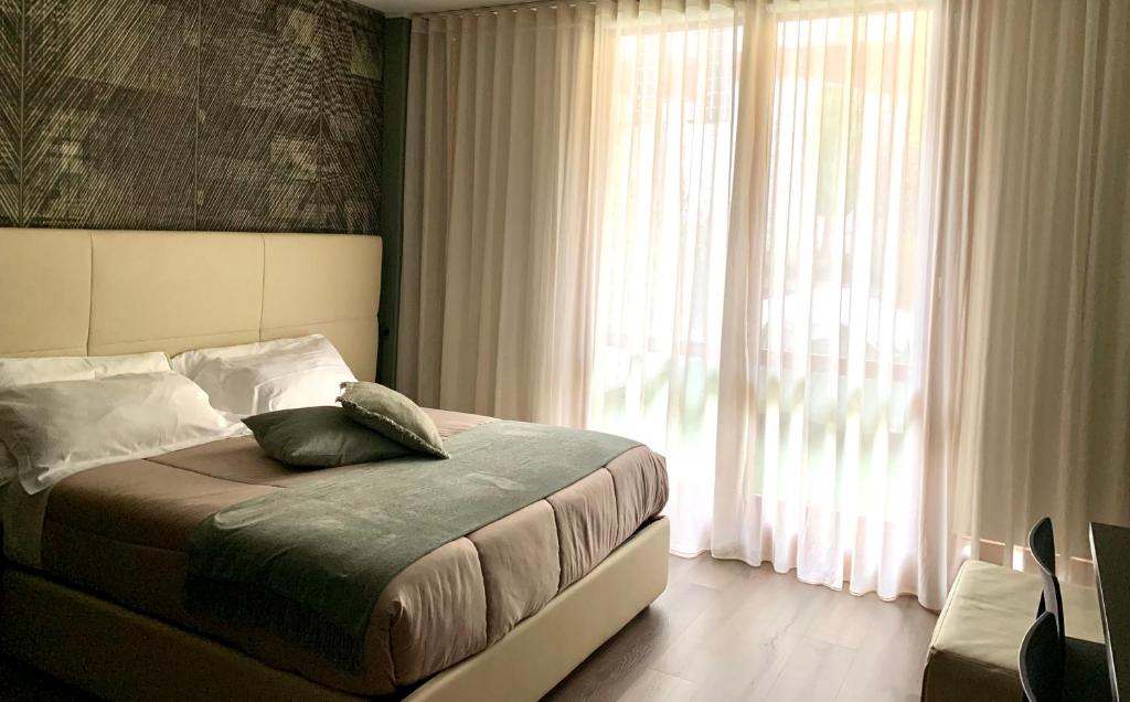 a bedroom with a bed and a large window at Casa vacanze Clorofilla in Bergamo