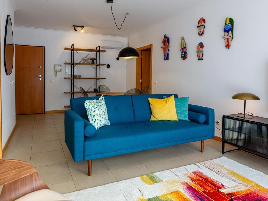 a blue couch sitting in a living room at Central Caldas w/ AC & Fast Net in Caldas da Rainha