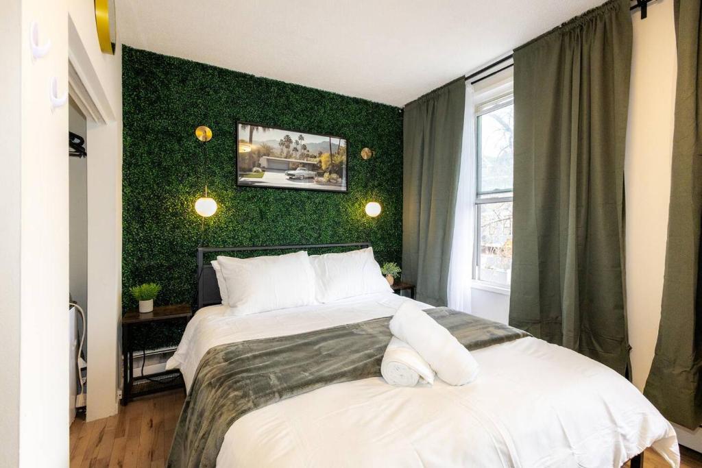 a bedroom with two beds and a green wall at Quiet & Walkable - Stampede, BMO, Nightlife & Eats in Calgary