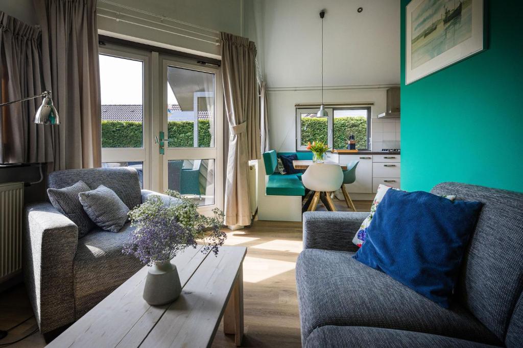 a living room with two couches and a table at Zeebungalows Terschelling in Formerum