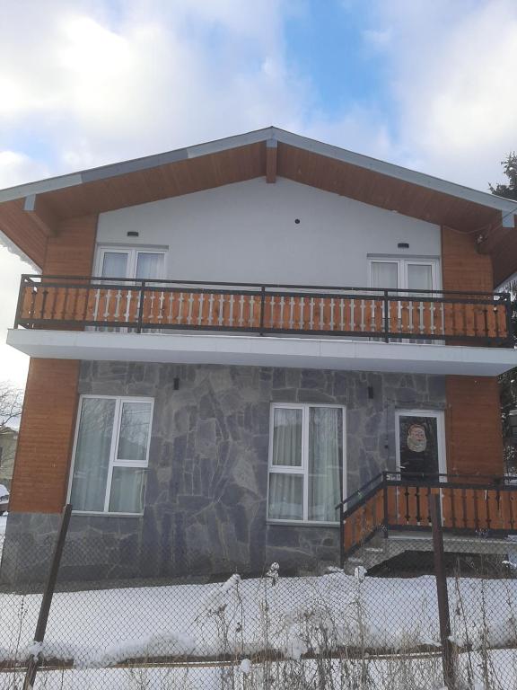 a house with a balcony on top of it at Maia's Cottage in Bakuriani