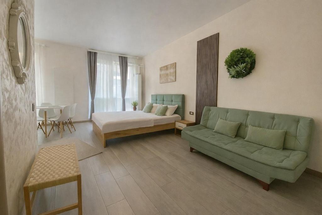 a living room with a green couch and a bed at Sasha Collection by AlezziNord10 in Constanţa
