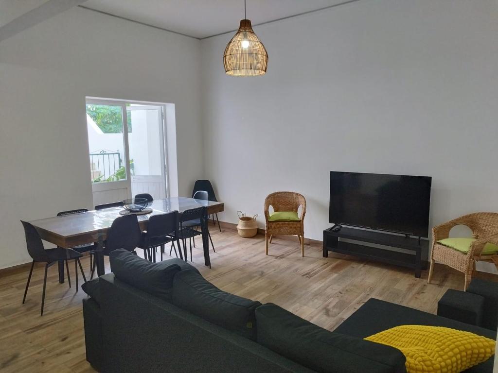 a living room with a couch and a table and a tv at Chill Spot - Faro Hostel in Faro
