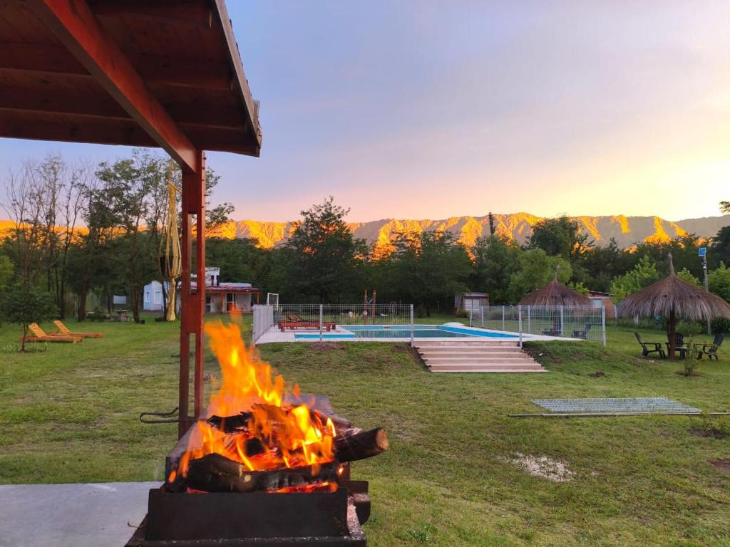 a fire pit in a yard with a pool at Complejo de cabañas Vida Paz in Las Calles