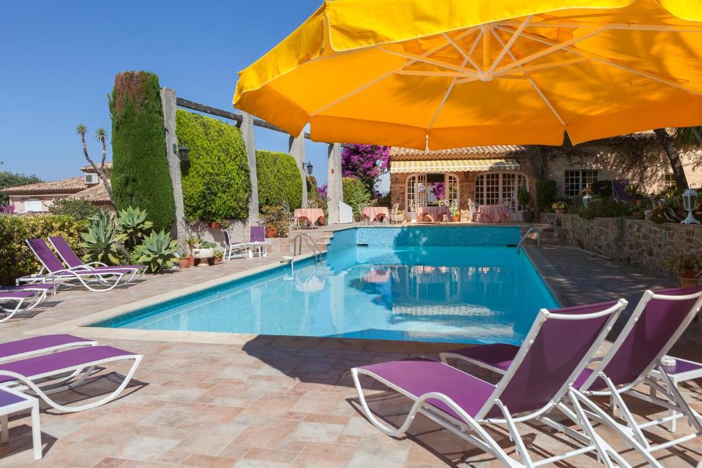 a swimming pool with chairs and umbrellas at L' Escapade Hôtel & Restaurant in Le Pradet