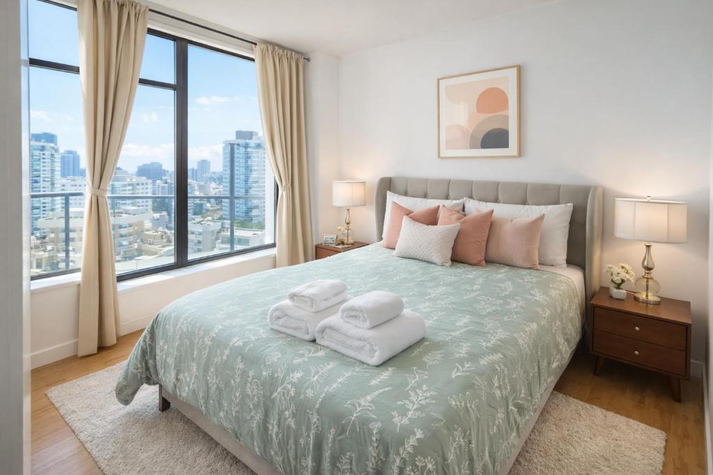 a bedroom with a large bed with towels on it at Pacific Pearl in Vancouver