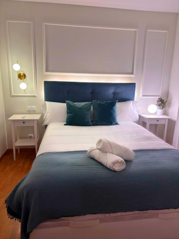 a bedroom with a large bed with a blue headboard at Apartamento Garnacha Rioja Aire Acondicionado,Wifi,BUS Búho in Lardero