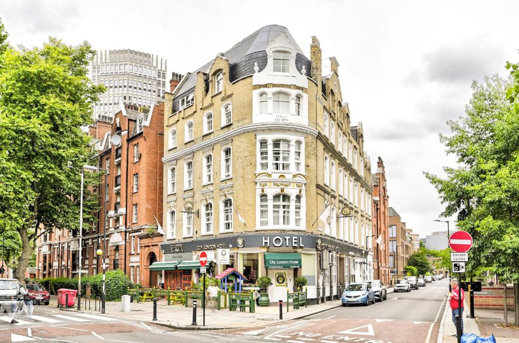 a large building on a city street with cars parked at City London Hotel in London