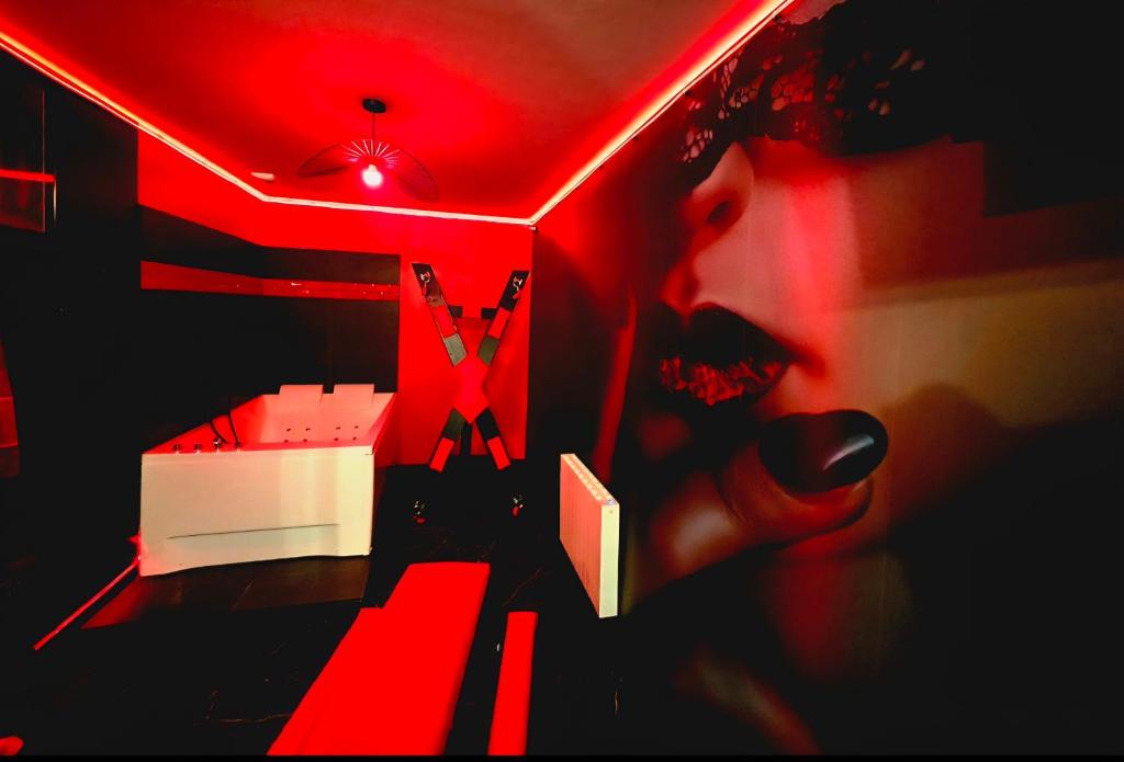 a room with a red lighted room with a bed at Lasuitesecretetdetente in Beauvais