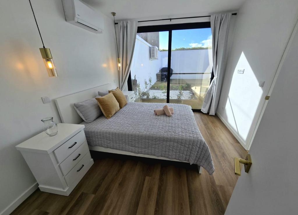 a small bedroom with a bed and a window at Atlantic Dreams II in Pico da Pedra