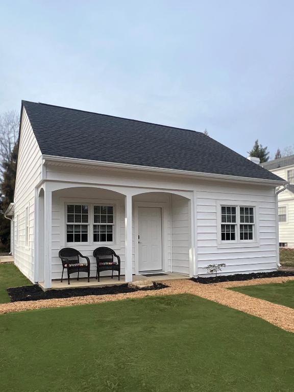 a white house with two chairs on the porch at Endicott Cottage in Richmond